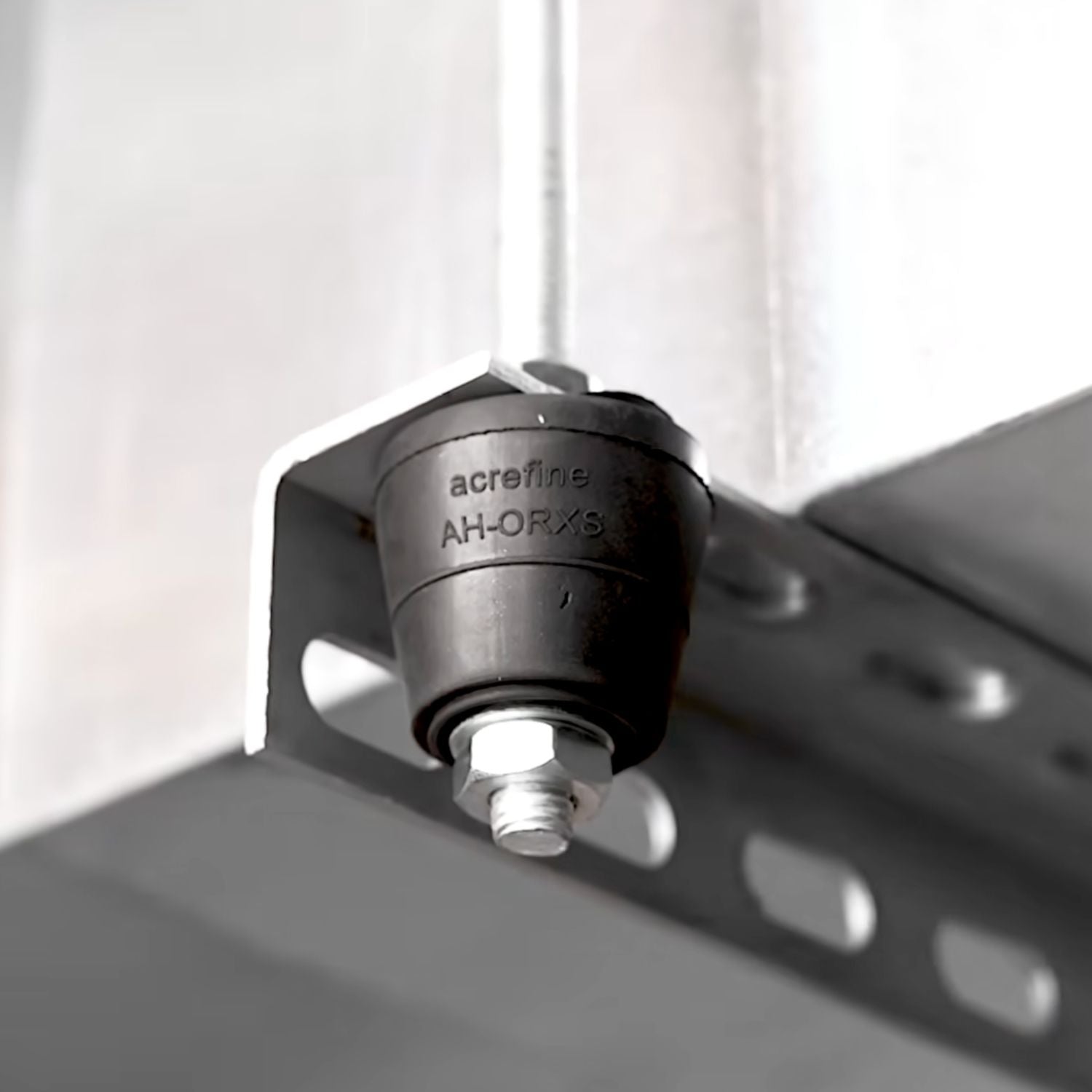 Acrefine rubber isolation element assembled on a steel L-bracket with a threaded rod and leveling nut.