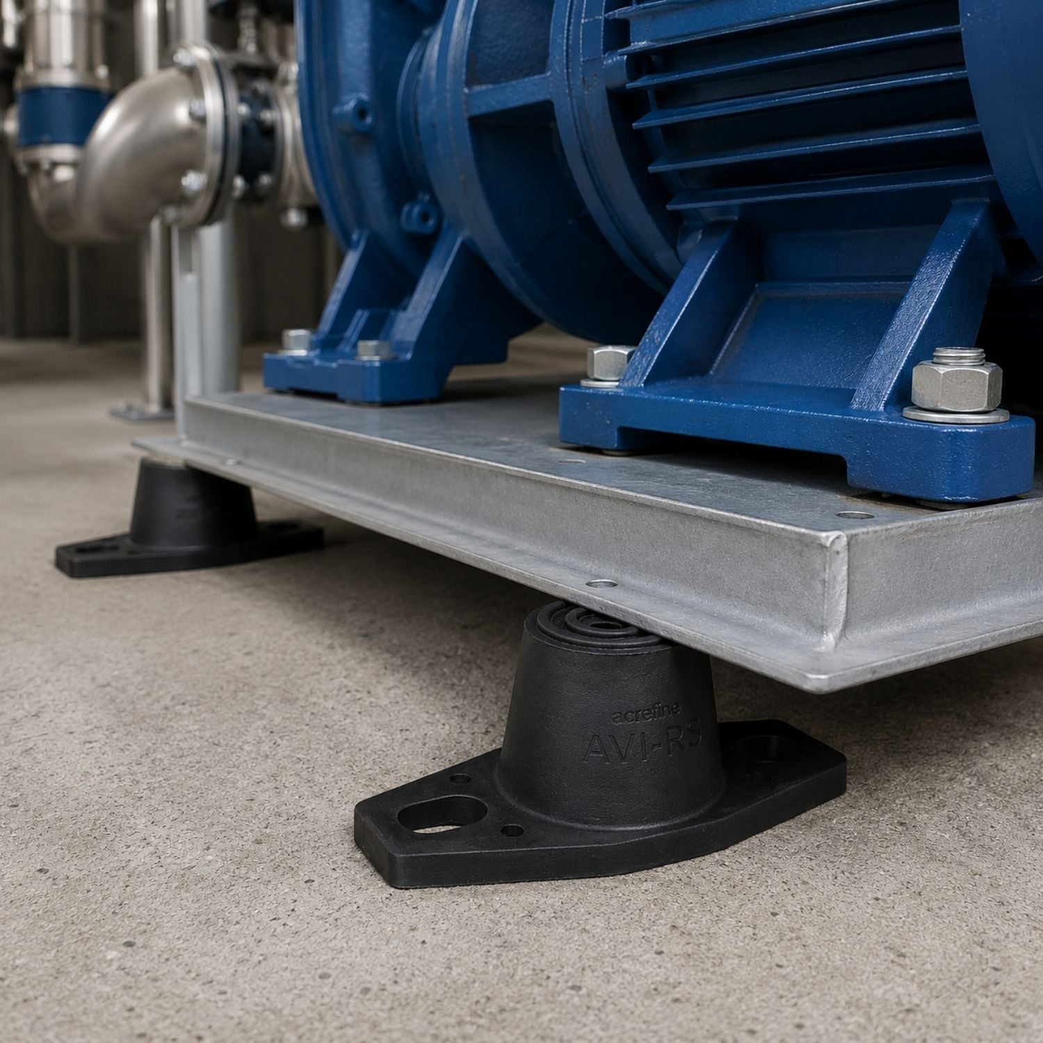 Acrefine floor-mounted rubber isolators installed under a heavy industrial mechanical pump base for structural vibration isolation.