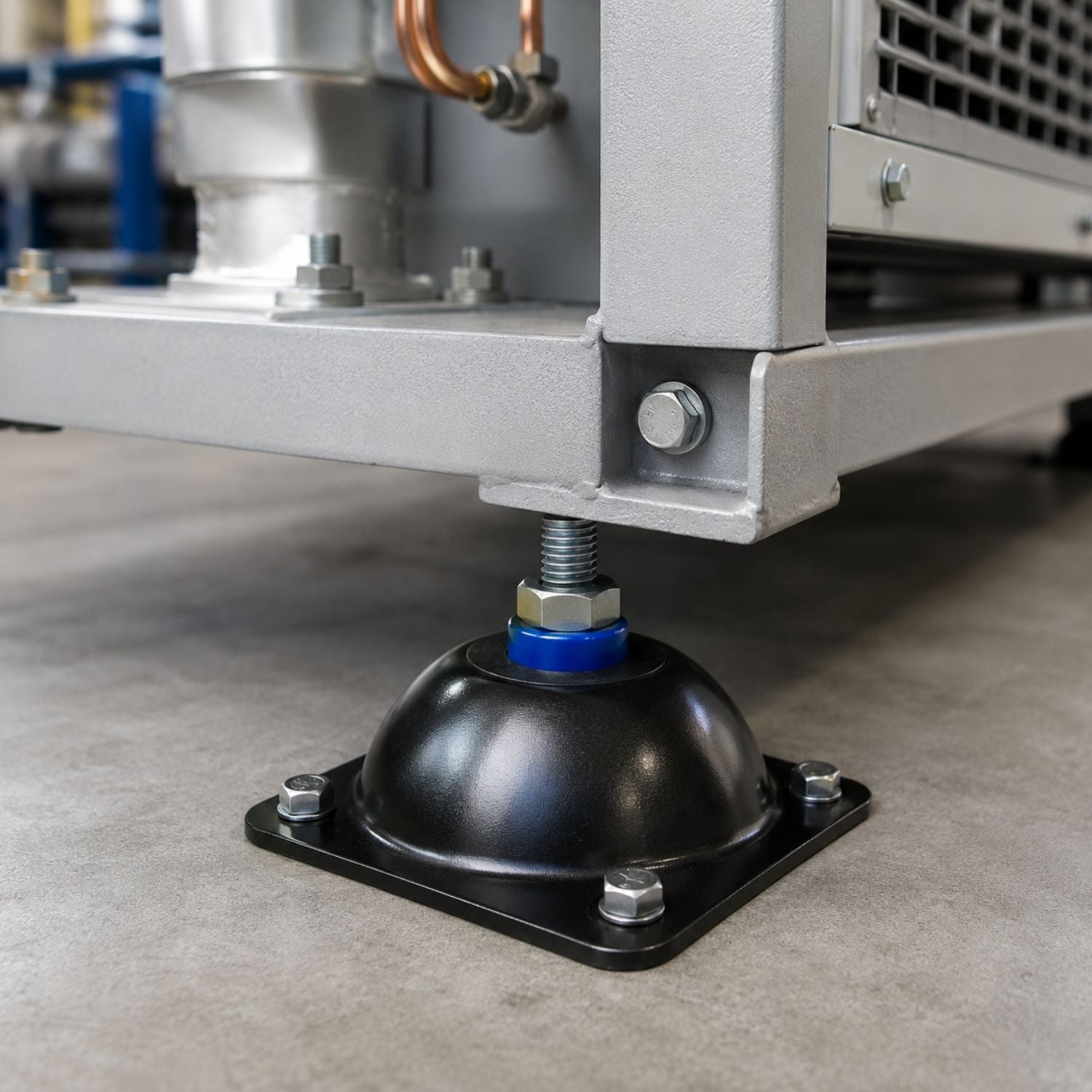 Acrefine steel-housed seismic rubber mount bolted to the floor under an industrial HVAC equipment base.