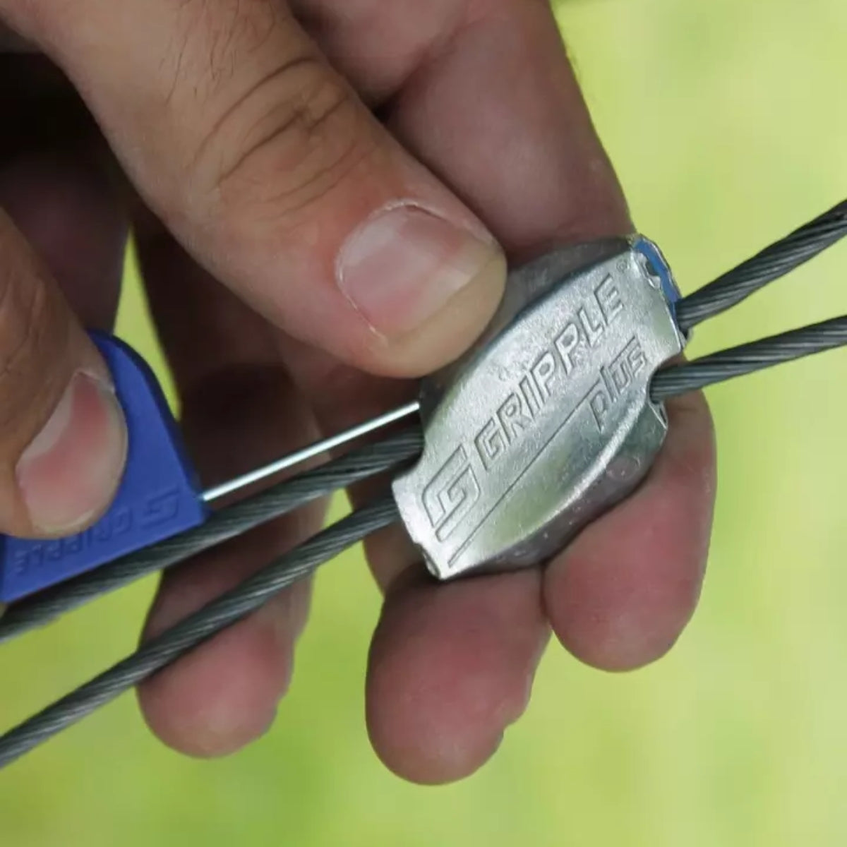 Close-up of a hand inserting the Flag Key into the release port of a Gripple fastener.