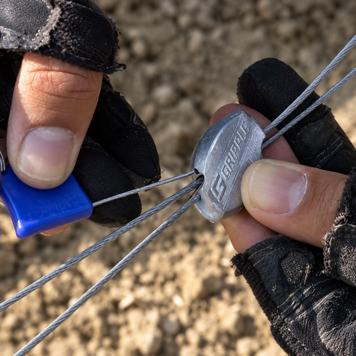 A gloved hand using the Flag Key to release a Gripple wire joiner outdoors.