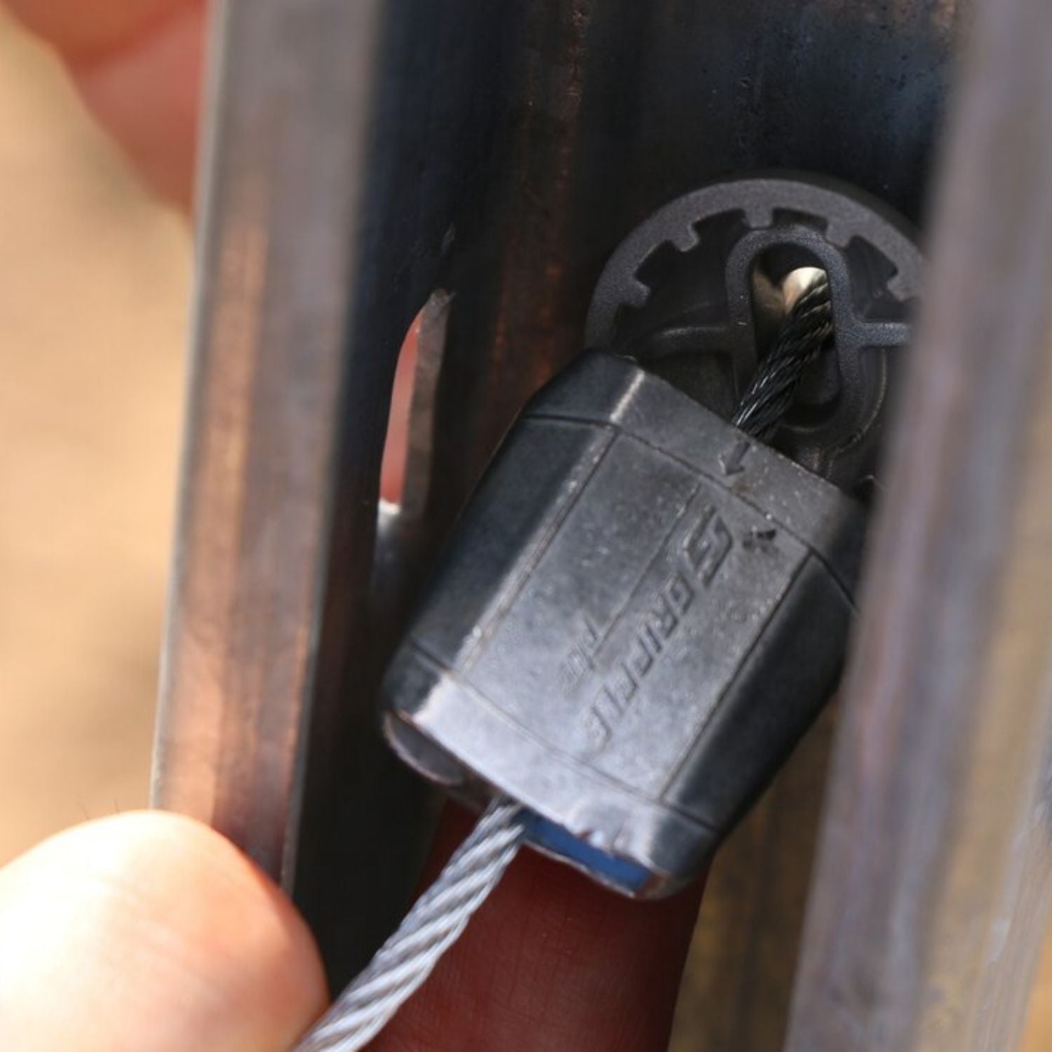 Macro view of a Gripple GP tensioner showing the safe tail wire return loop routing through the spare integral channel inside the post.