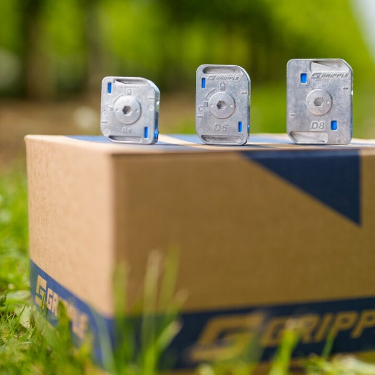 Three Gripple Dynamic units standing on a Gripple branded box outdoors.