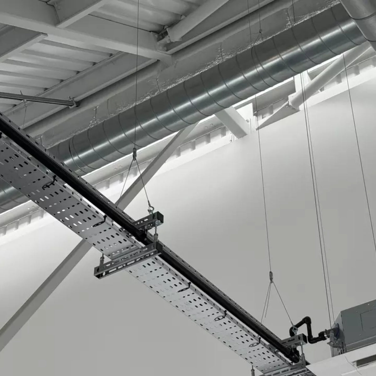 Trapeze and cable tray suspended from Y-Fit hangers in a services void.