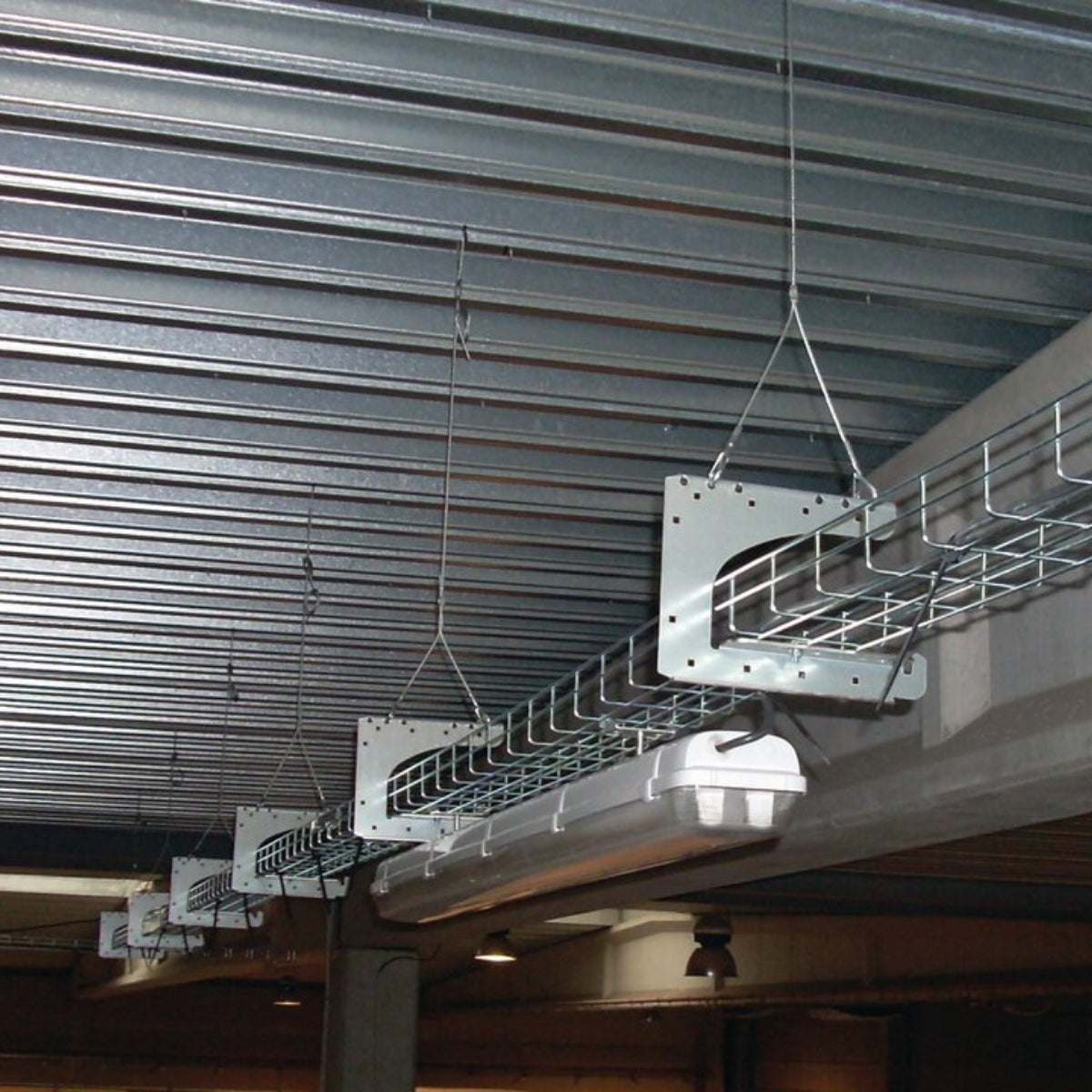 Cable trays hung on Y-Fit hangers under an industrial roof deck.